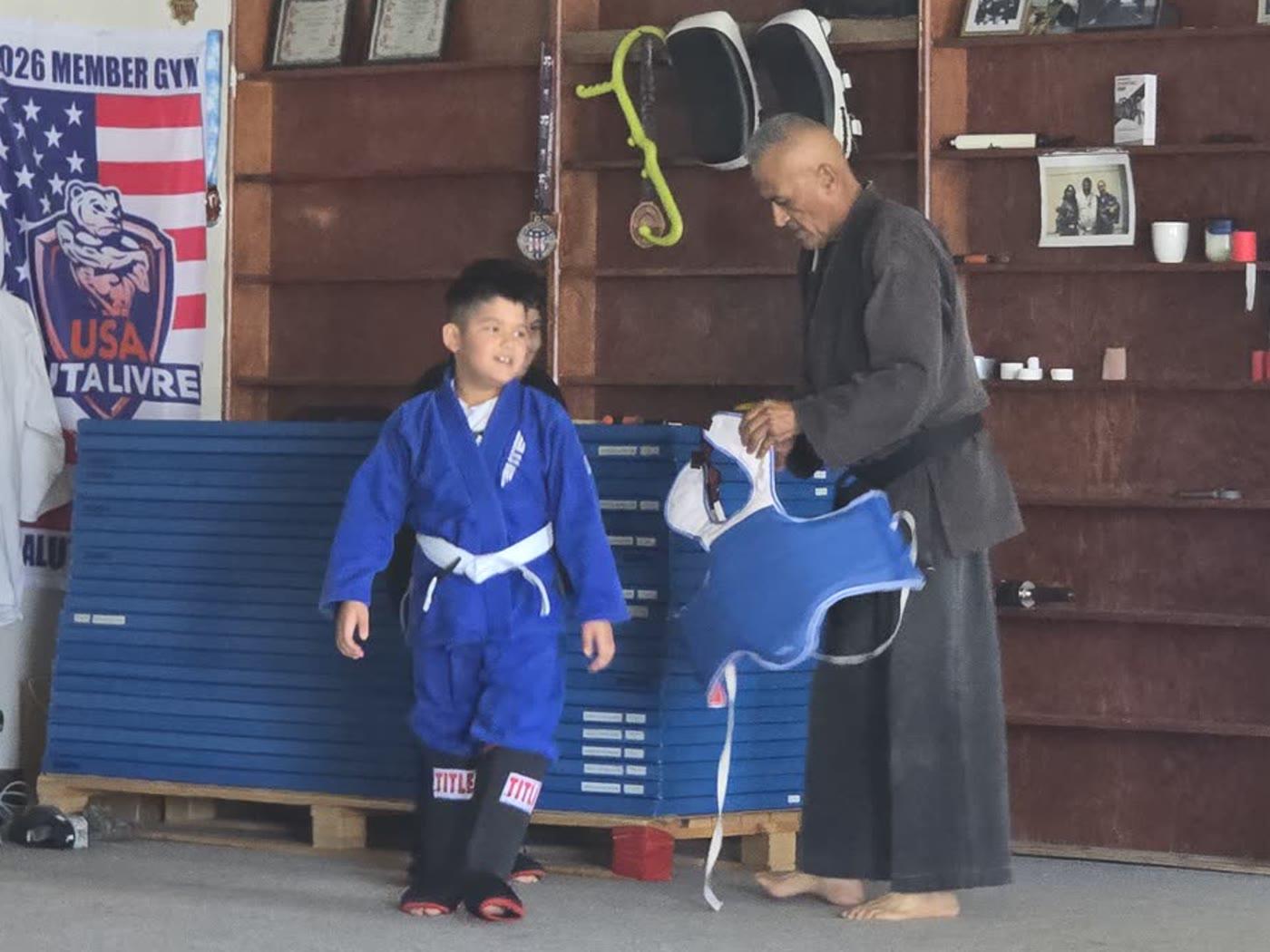 Young student working pad drills with an instructor at our dojo