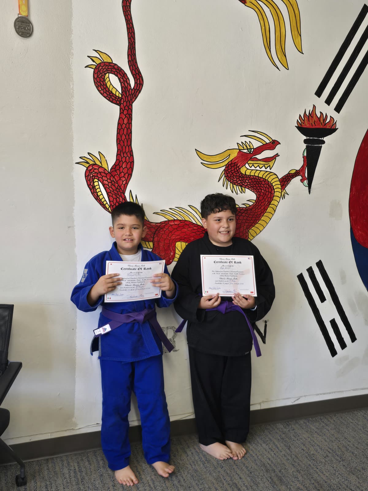Two students showing their rank certificates